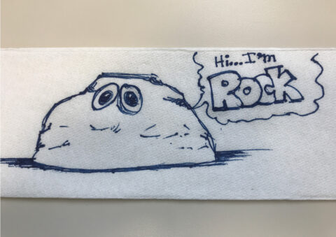 An original illustration of a rock done on a napkin.